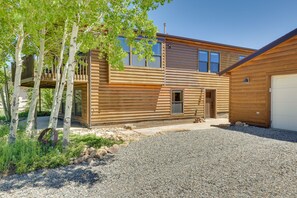 A log cabin with a deck and a garage. - Updated Silverthorne Home w/ Hot Tub & Mtn Views! (Silverthorne)
