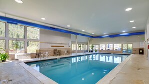 An indoor swimming pool with clear blue water, surrounded by a tiled floor and walls. There are windows allowing natural light and views of the outdoors. - Keystone Lake Haven: Heated Pool & Ski Shuttle! (Keystone)