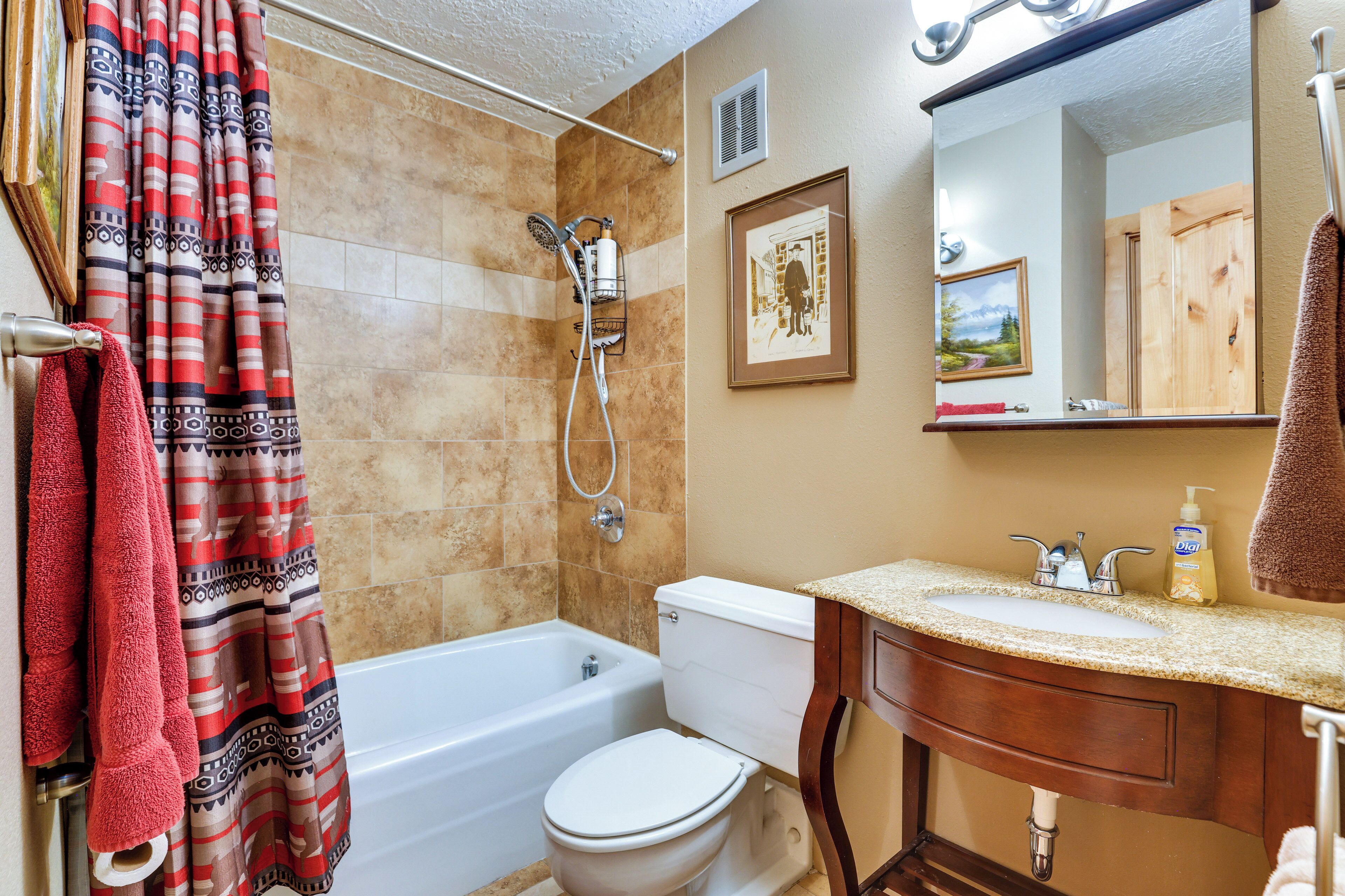 A bathroom with a bathtub, toilet, and sink.