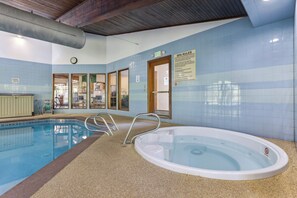 Ein Innenpool mit Whirlpool, gefliesten Wänden und einem Schild mit den Spa-Regeln.
