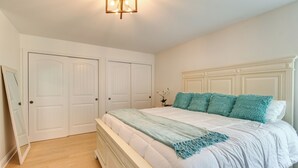 A bedroom with a white bed, teal pillows, and a white headboard. - Prime Peoria Retreat w/ Deck & Fireplace! (Peoria)