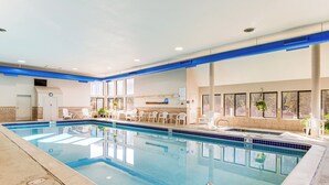 An indoor swimming pool with clear blue water, surrounded by white lounge chairs and a sunlit area with large windows. - 1 Mi to Keystone Resort: Mtn-view Family Escape! (Keystone)