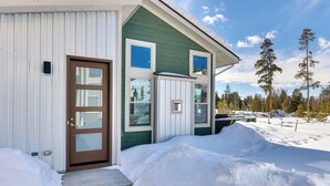 A house with a green exterior, a brown front door, and multiple windows. - Fraser Vacation Rental - Shuttle to Winter Park! (Fraser)
