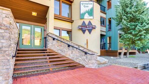 Ein Hotel Eingang mit einer Steintreppe, die zu einer grünen Tür führt, mit einem Schild für Foxpine Inn und einem Schild für das Double Diamond Restaurant.