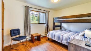 A bedroom with a bed, a chair, a small table, and a window with curtains. - Fraser Condo Rental w/ Balcony, Mountain Views! (Fraser)