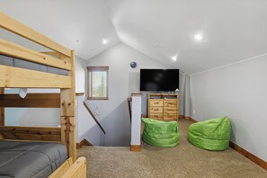 A room with a bunk bed, a desk with a computer, a television, and two bean bags. - Fraser Getaway - 7 Mi to Winter Park Ski Resort! (Winter Park)
