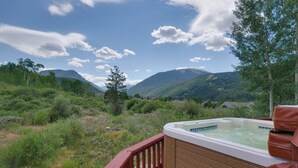 Ein Whirlpool auf einer Terrasse mit einer Berglandschaft im Hintergrund.
