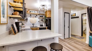 A modern kitchen with a central island, bar stools, and a herringbone-patterned backsplash. - Pool + Ski-in Access: Copper Mountain Condo! (Copper Mountain)