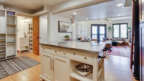 A modern kitchen with a large island, open shelving, and a view into the living area. - Copper Mtn Condo w/ Heated Pool: Ski-in/walk-out! (Copper Mountain)