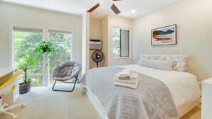 A bedroom with a bed, a ceiling fan, a chair, a desk, and a window with a view of trees. - Beautiful Boulder Townhome: Walk to CU & Pearl St! (Boulder)