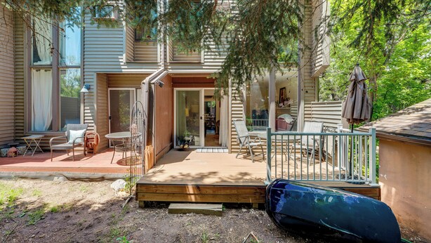 A two-story house with a covered patio area, a sliding glass door entrance, and a small deck. - Beautiful Boulder Townhome: Walk to CU & Pearl St! (Boulder)