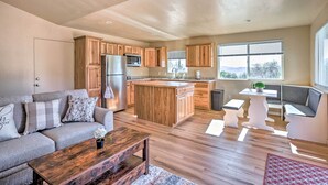A modern kitchen with wooden cabinets, a central island, and a built-in microwave. - Comfy Oakhurst Duplex Near Hiking & Sightseeing! (Oakhurst)