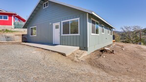 A single-story house with a sloped roof, a front porch, and a driveway leading to the entrance. - Comfy Oakhurst Duplex Near Hiking & Sightseeing! (Oakhurst)