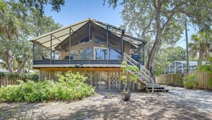A wooden cabin with a glass enclosure, a covered deck, and a staircase leading to the entrance. - Scenic Siesta Key Home ~ 1 Mi to Village & Beach! (Siesta Key)