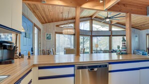A modern kitchen with wooden cabinets, a dishwasher, and a large island with blue accents. - Scenic Siesta Key Home ~ 1 Mi to Village & Beach! (Siesta Key)