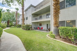 A multi-story residential building with a landscaped garden, outdoor seating area, and a visible balcony. - Family-friendly St George Condo w/ Community Pools (St. George)