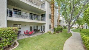 A two-story apartment building with balconies, a patio with outdoor furniture, and a well-maintained lawn. - Family-friendly St George Condo w/ Community Pools (St. George)