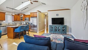 A modern kitchen with wooden cabinets, a central island with bar stools, a built-in microwave, and a large refrigerator. - Cheery Tacoma Vacation Rental: 7 Mi to Owen Beach! (Tacoma)