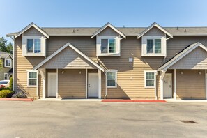 A multi-story residential building with a symmetrical facade, multiple windows, and a central entrance. - Charming Tacoma Retreat w/ Patio & 2 Fireplaces! (Tacoma)