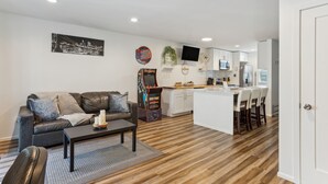 A modern living room with a sofa, coffee table, and a gaming console. - Charming Tacoma Retreat w/ Patio & 2 Fireplaces! (Tacoma)