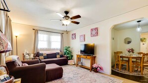 A living room with a sofa, ottoman, TV, and a ceiling fan. - Cottage w/ Furnished Deck: 1 Mi to Dtwn Craig! (Craig)