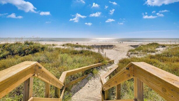 A wooden boardwalk leading to a beach with a clear sky. - Beachfront St Augustine Beach Condo, Stunning View (St. Augustine)