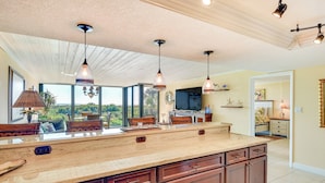 A spacious kitchen with a large island, pendant lighting, and a view of the outdoors. - Beachfront St Augustine Beach Condo, Stunning View (St. Augustine)