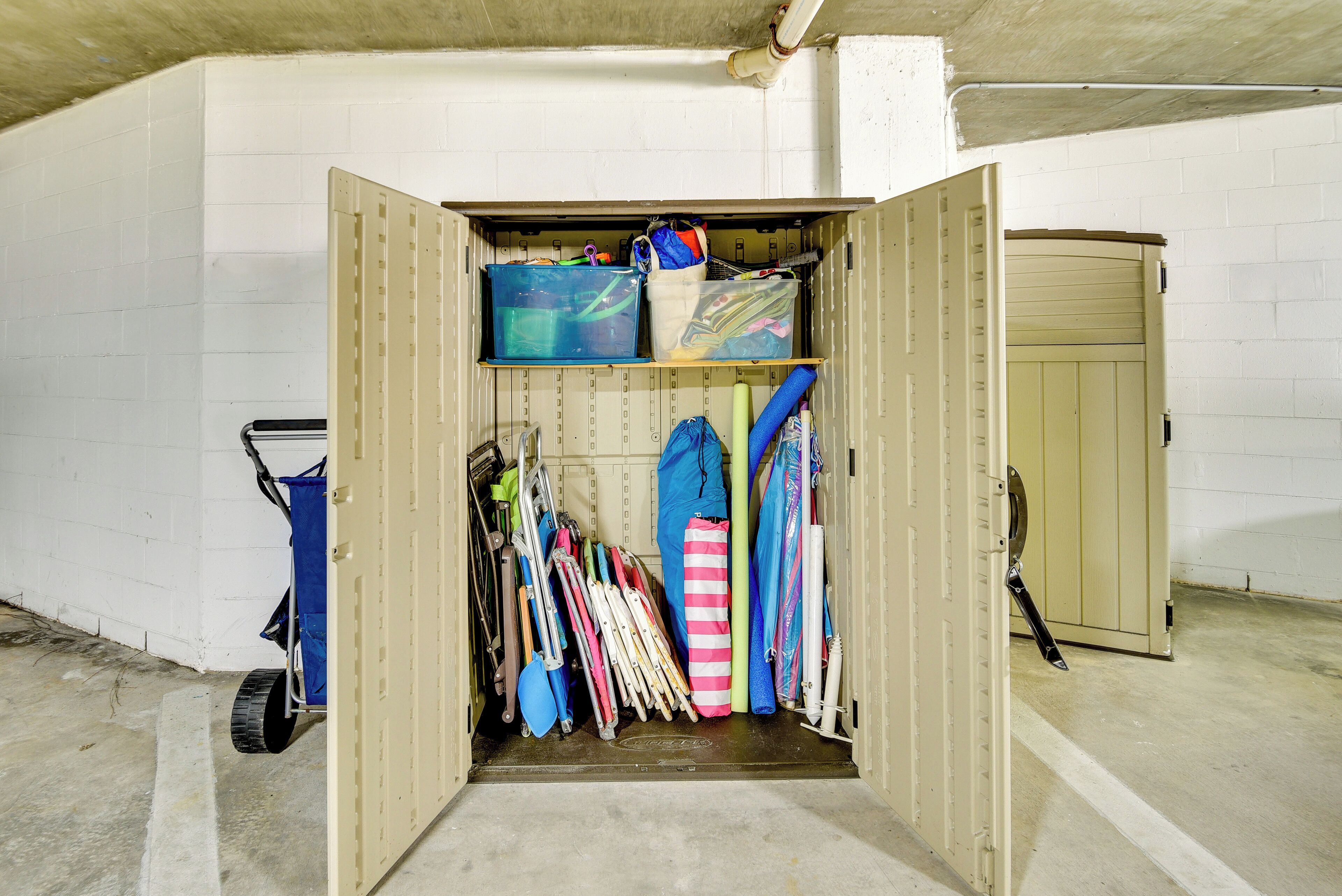 A storage unit with various items like bags, a blue container, and a striped bag.