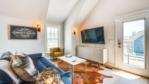 A modern living room with a sofa, a coffee table, a television, and a large window with a view of buildings. - 14 Mi to Dtwn Denver: Sleek Westminster Home (Westminster)
