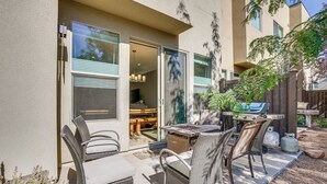 A patio with wicker furniture, a grill, and a sliding door leading to an interior space. - Moab Vacation Rental: Pool & Hot Tub Access! (Moab)
