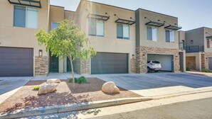 A modern two-story residential building with a garage, a driveway, and a landscaped front yard with rocks and a tree. - Moab Vacation Rental: Pool & Hot Tub Access! (Moab)