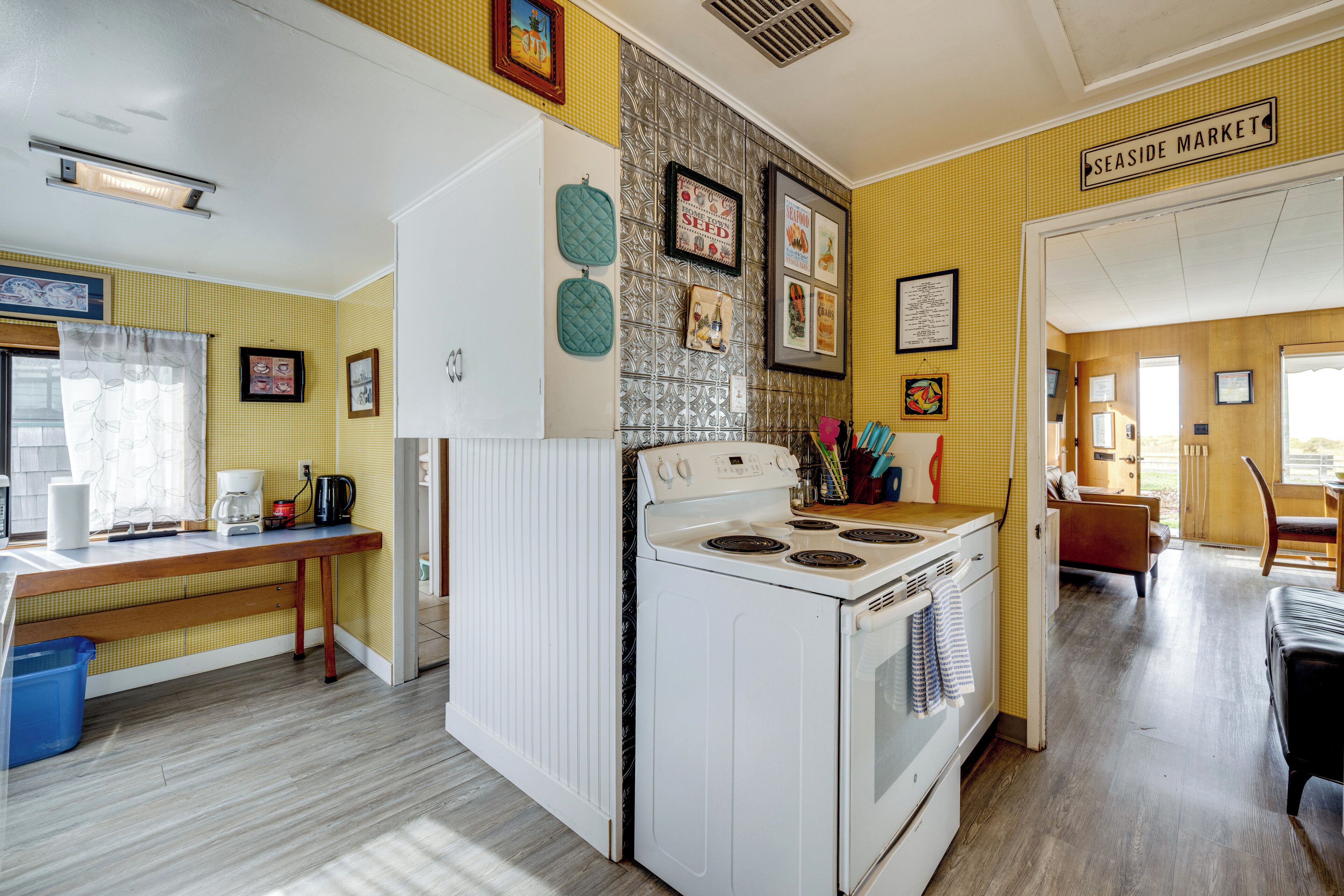 A kitchen with a stove, a refrigerator, and a dining area with a table and chairs.