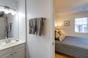 A bathroom with a sink, mirror, and towel rack.