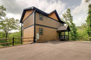 A two-story building with a wooden exterior and a covered porch. - Cobbly Nob Resort Cabin: Hot Tub, Pool & Views! (Gatlinburg)