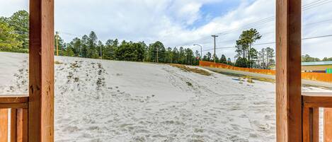 A snow-covered slope with a wooden structure in the foreground.