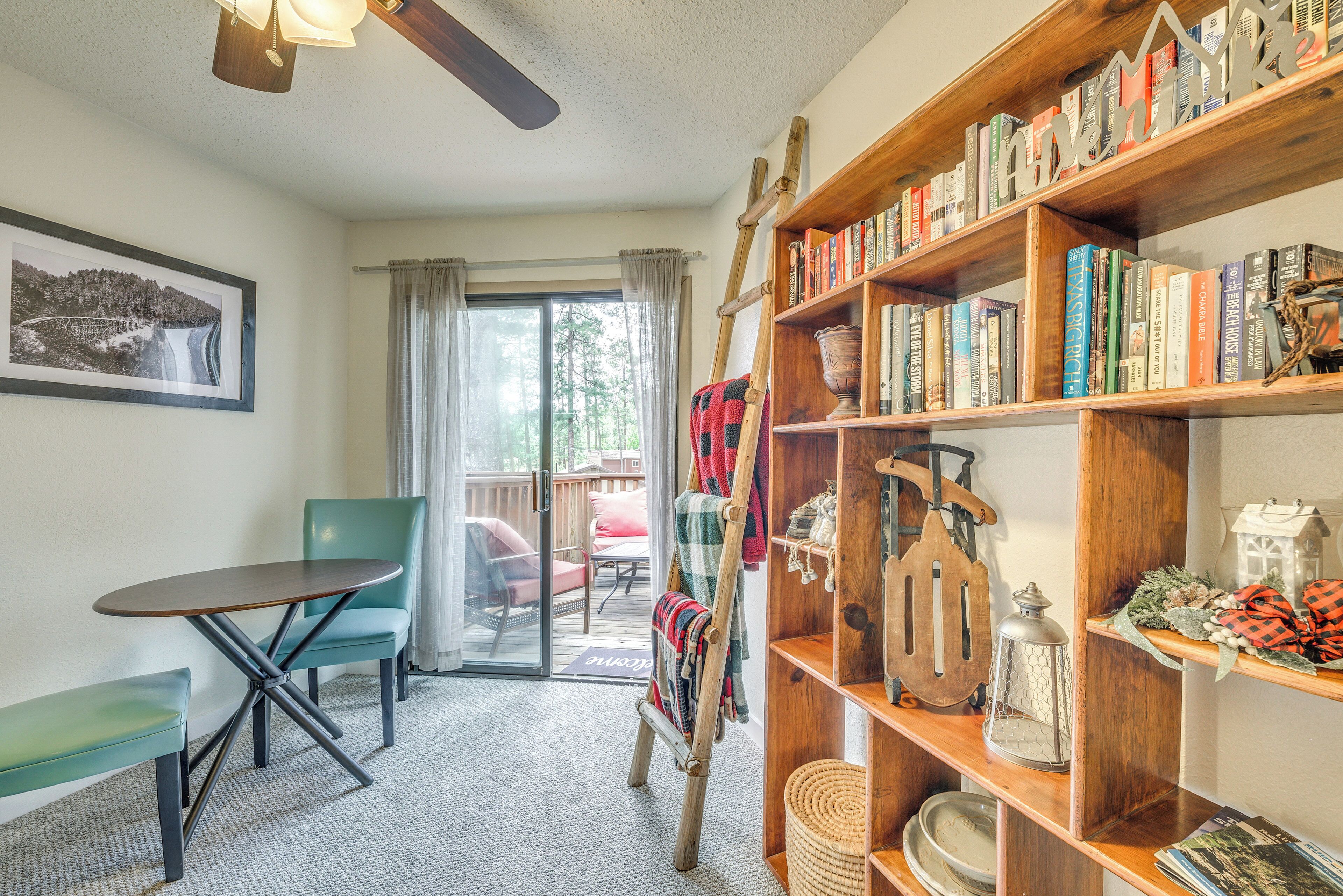 Una habitación acogedora con una estantería de madera, una mesa de comedor y una silla.