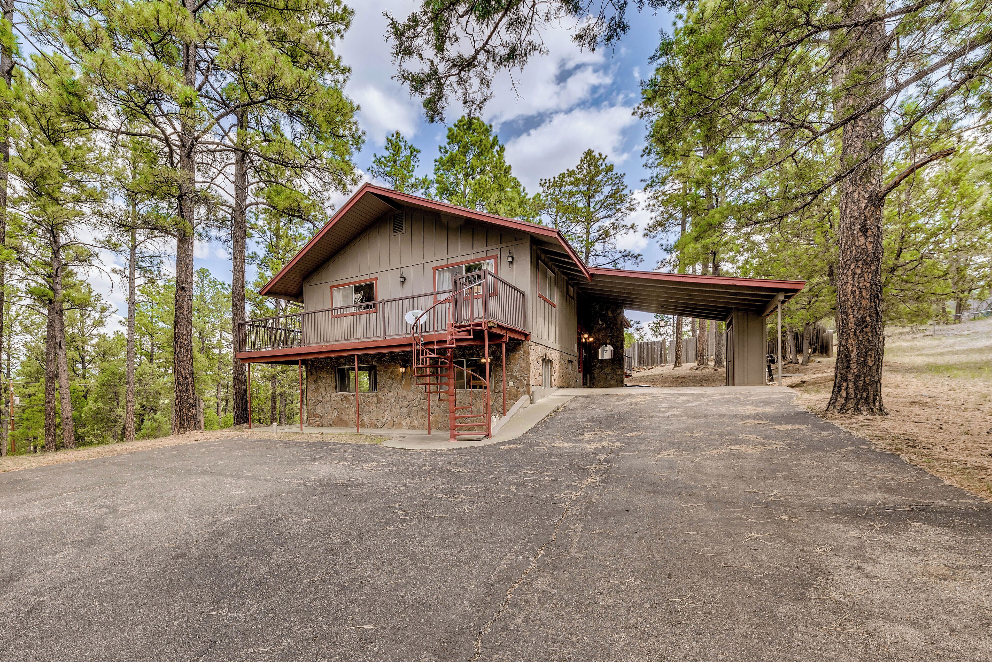 A two-story cabin with a covered porch and a staircase leading to the upper level.