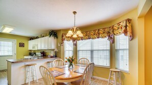 A kitchen with a dining area, featuring a central island, white cabinets, and a chandelier. - Pigeon Forge Home w/ Deck & Hot Tub Near Town! (Pigeon Forge)