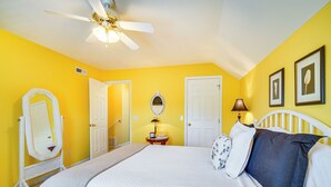 A bedroom with a bed, a ceiling fan, a dresser, a mirror, and a door. - Pigeon Forge Home w/ Deck & Hot Tub Near Town! (Pigeon Forge)