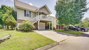 A two-story house with a covered front porch and a garage. - Pigeon Forge Home w/ Deck & Hot Tub Near Town! (Pigeon Forge)