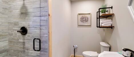 Un baño con ducha, inodoro y lavamanos.