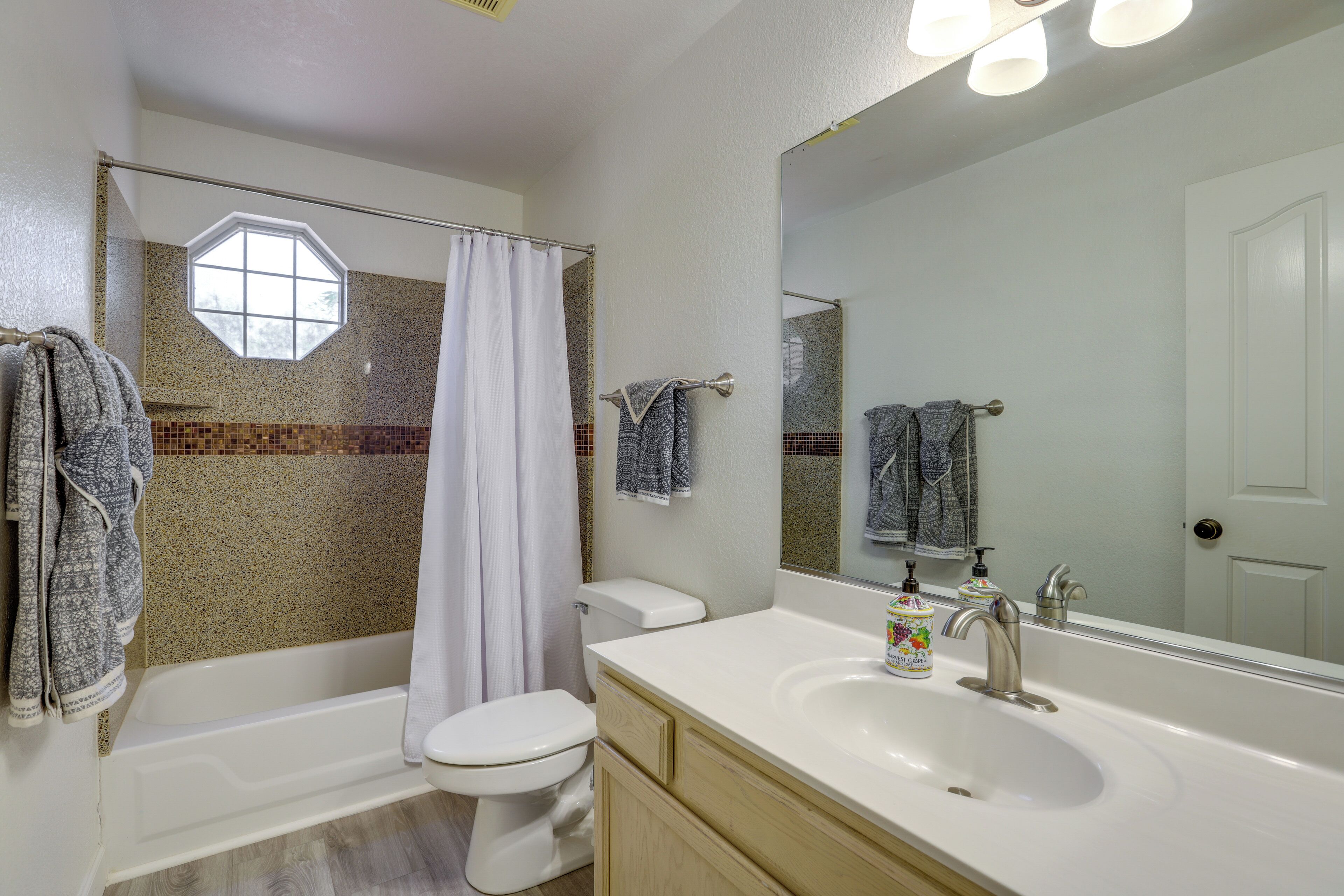 A bathroom with a bathtub, toilet, and sink.