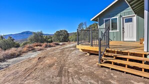 A house with a wooden deck, a white door, and a view of mountains. - Oakhurst Duplex ~ 13 Mi to Yosemite National Park! (Oakhurst)