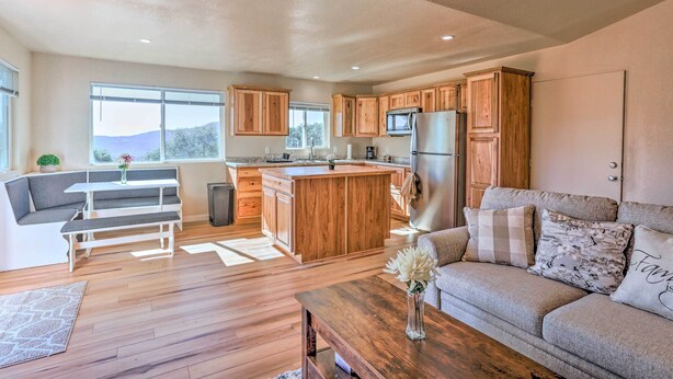 A modern kitchen with wooden cabinets, a central island, and a built-in microwave. - Oakhurst Duplex ~ 13 Mi to Yosemite National Park! (Oakhurst)