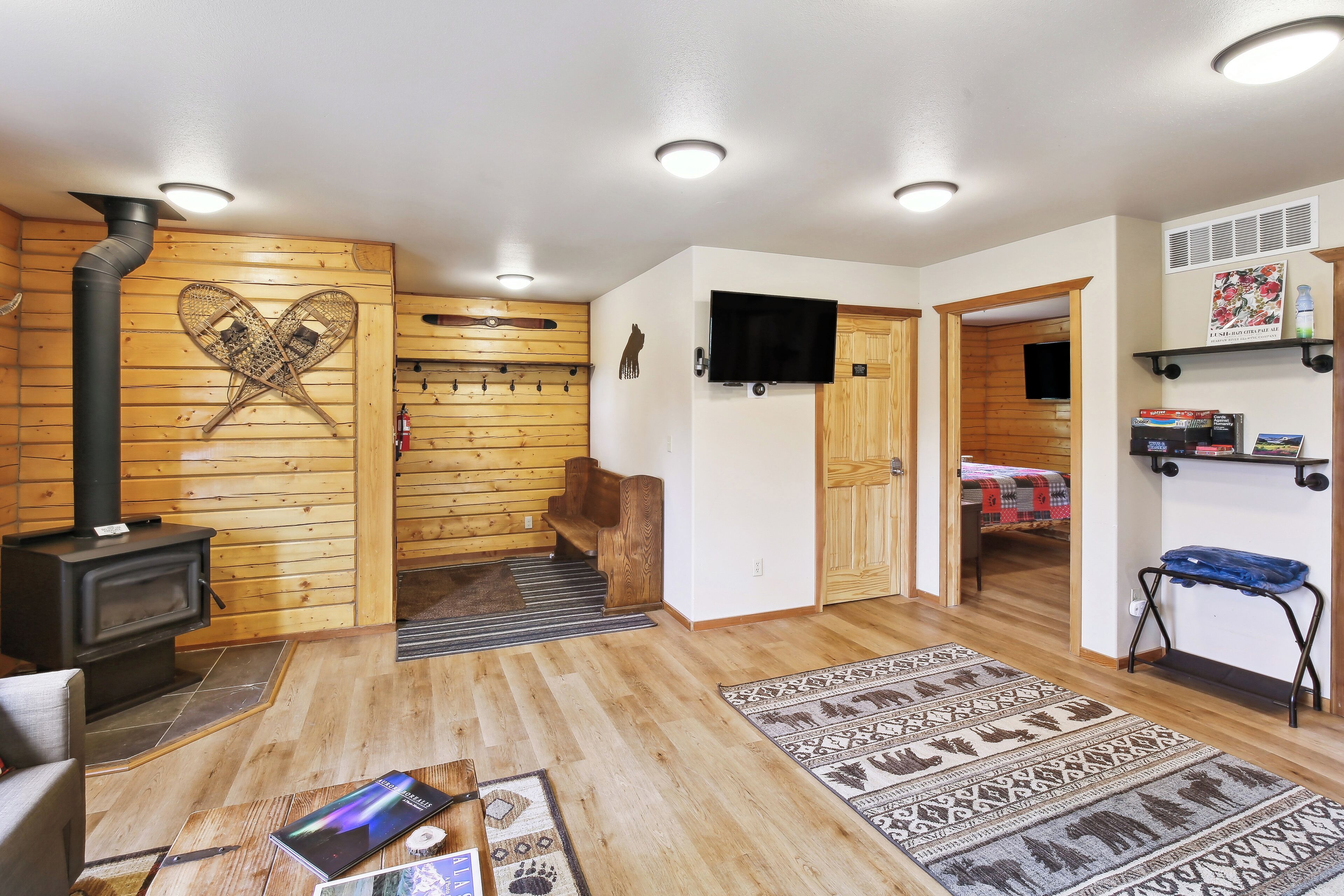 A cozy room with a wooden interior, a fireplace, a television, and a bed.