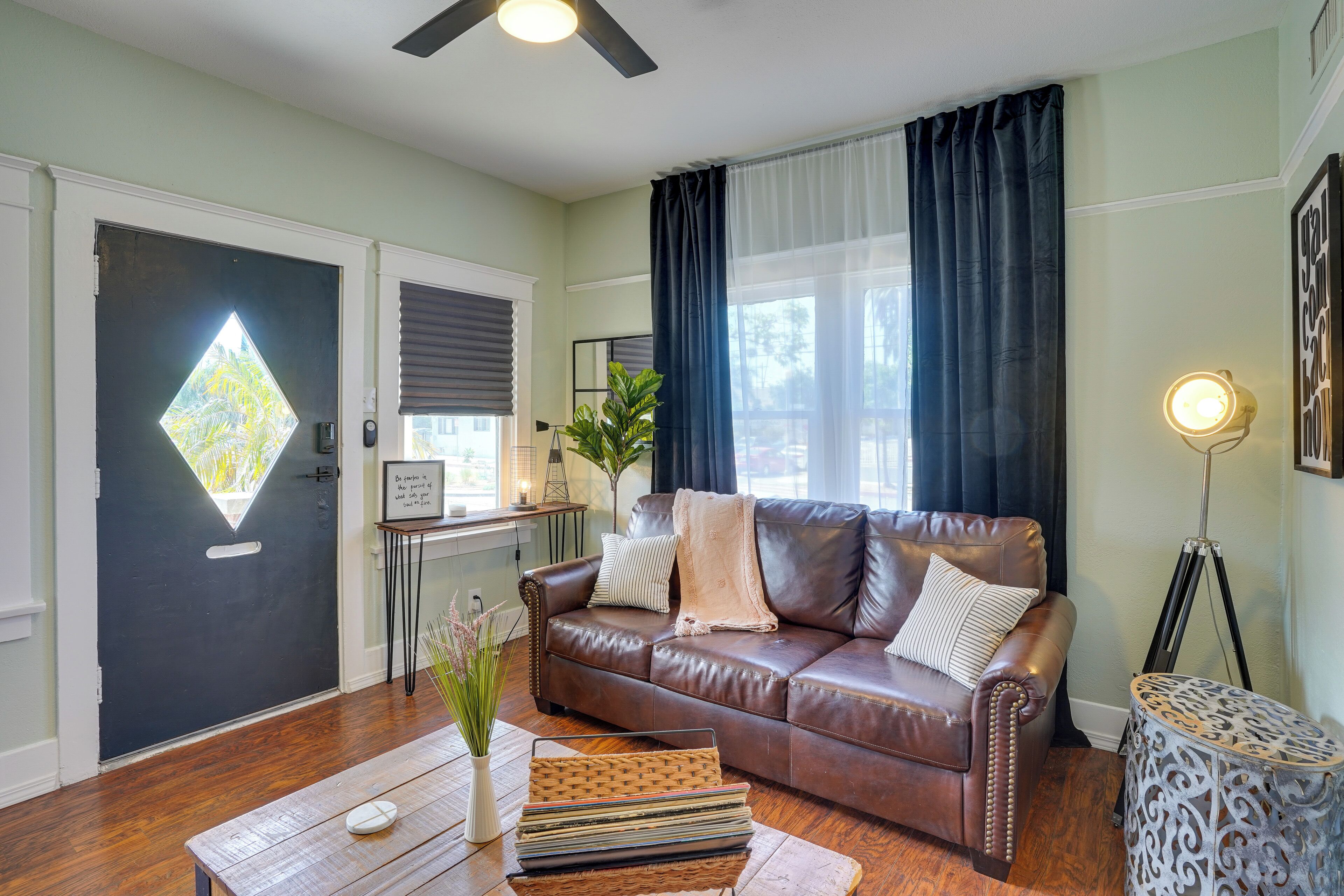 A living room with a brown leather sofa, a coffee table, and a side table with a lamp.
