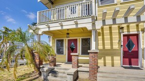 A two-story house with a balcony, red doors, and a small front porch. - 1 Mi to Dtwn! Bright Long Beach Apartment (Long Beach)