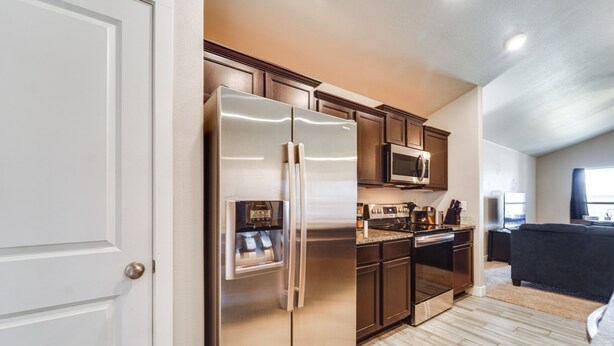 A modern kitchen with stainless steel appliances, wooden cabinets, and a built-in microwave. - Pet-friendly Lubbock Home - 10 Mi to Downtown (Lubbock)