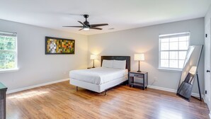 A bedroom with a bed, bedside lamps, a ceiling fan, a painting, and a window. - 2 Mi to Dtwn Durham: Home Near Universities (Durham)