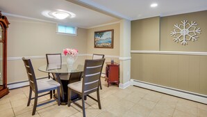 A dining area with a round glass table, two chairs, a vase with flowers, a painting on the wall, and a decorative snowflake. - New Fairfield Vacation Rental w/ Lake Views! (New Fairfield)